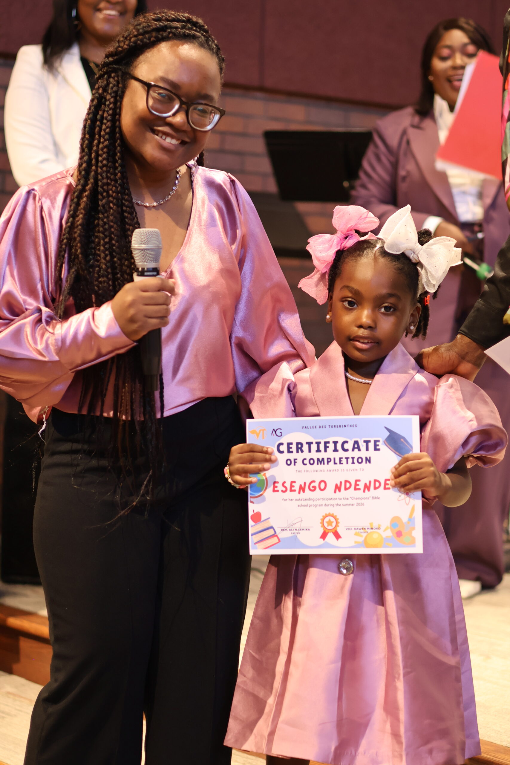 A child proudly holding a church summer school certificate